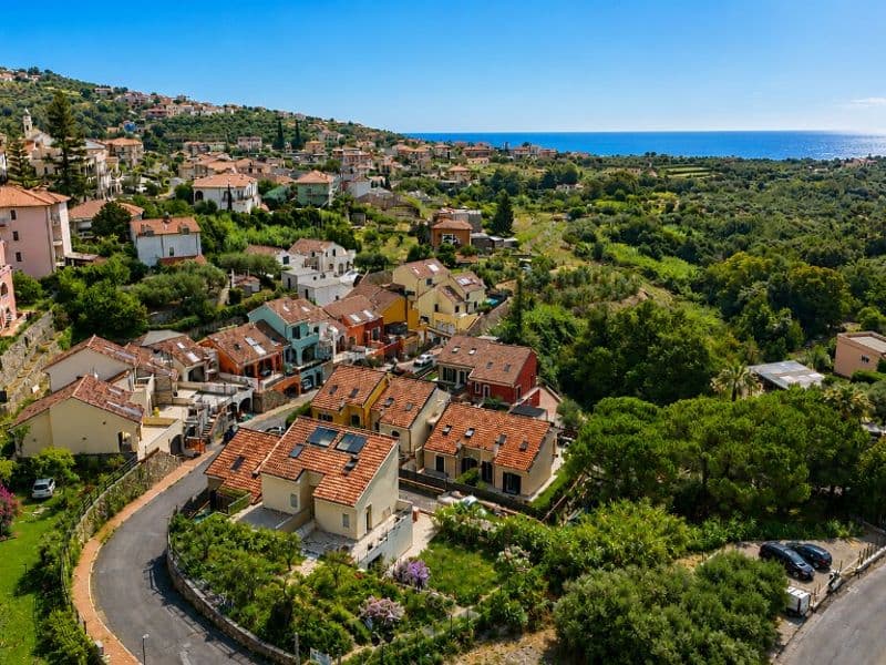 I Borghi a Boissano — Panoramica del borgo di Boissano con case colorate, verde e vista sul mare