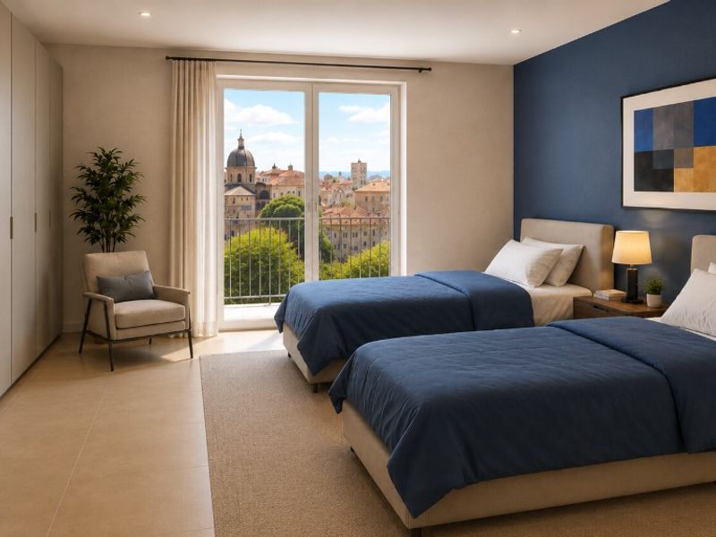 Palazzo Stella a Loano — Camera con due letti singoli, parete blu e vista sul centro storico di Loano